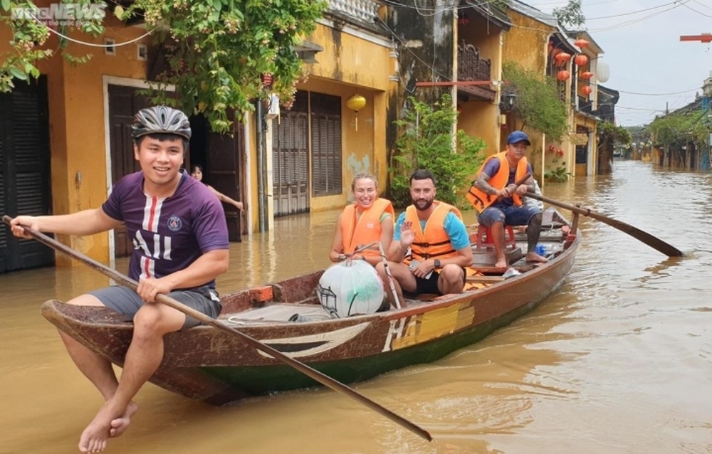 Kiếm bộn tiền nhờ chèo thuyền rước khách tham quan phố cổ Hội An ngập lụt - Ảnh 1.