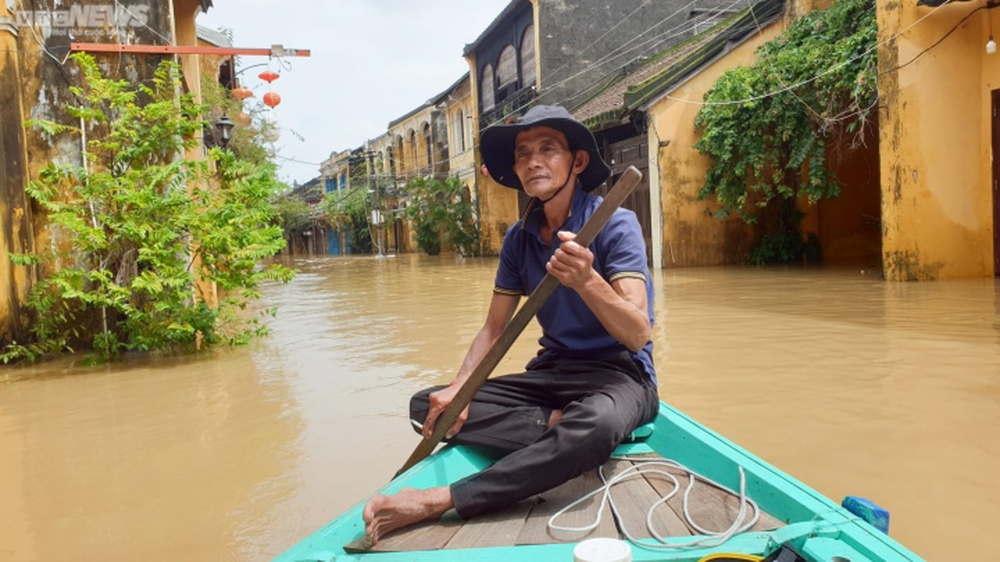 Kiếm bộn tiền nhờ chèo thuyền rước khách tham quan phố cổ Hội An ngập lụt - Ảnh 2.