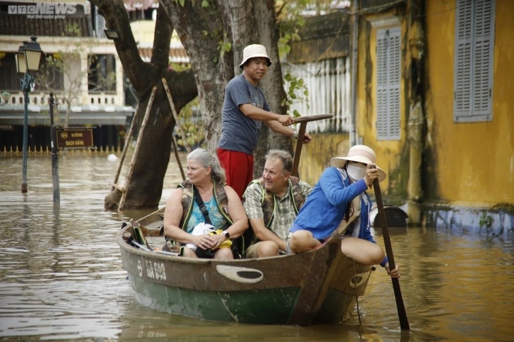 Kiếm bộn tiền nhờ chèo thuyền rước khách tham quan phố cổ Hội An ngập lụt - Ảnh 4.