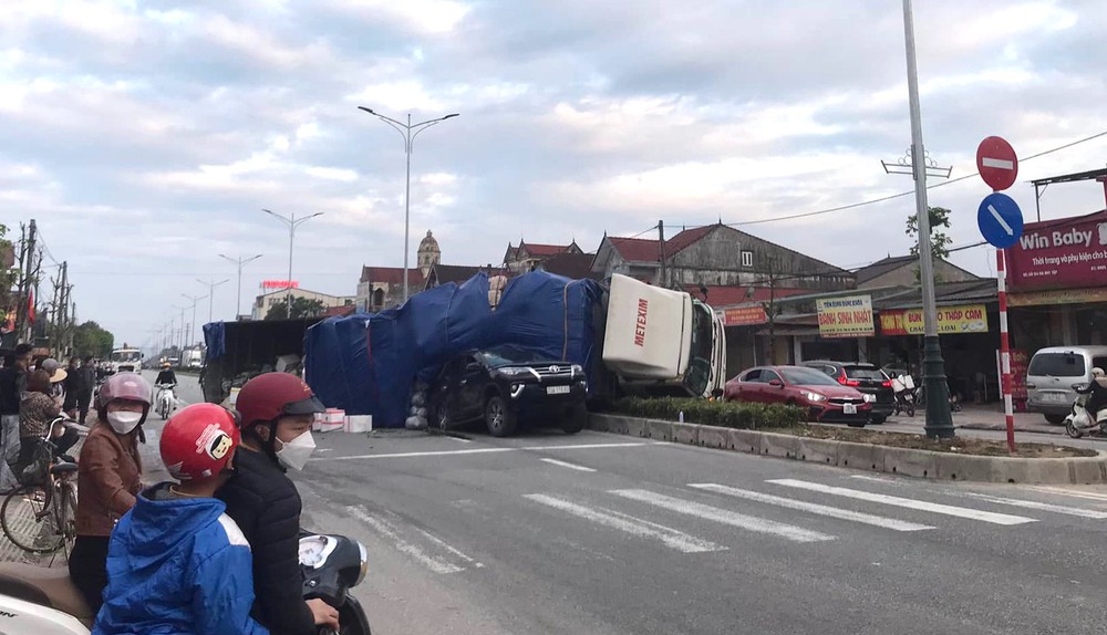 Stopping at a red light, a 7-seater car was hit by a truck and then partially crushed behind - Photo 1.