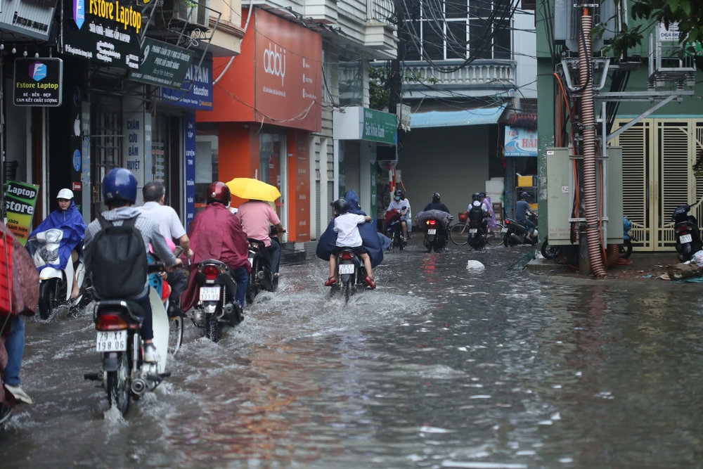 Người Dân Hà Nội lội bì bõm trên đường sau cơn mưa lớn kéo dài 30 phút - Ảnh 1.