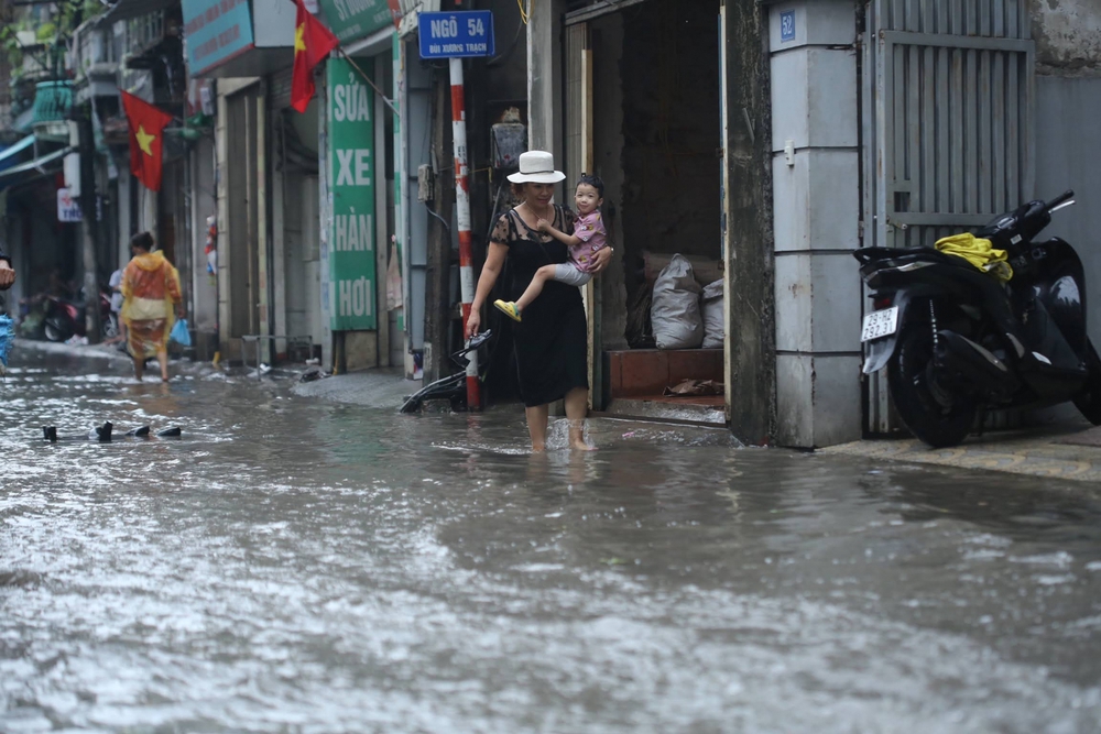 Người Dân Hà Nội lội bì bõm trên đường sau cơn mưa lớn kéo dài 30 phút - Ảnh 8.