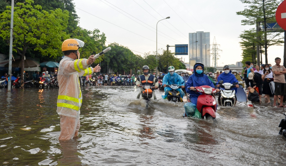 Bám hàng rào tránh lụt, bỏ xe ăn bim bim trong trận ngập diện rộng ở Thủ đô chiều nay - Ảnh 7.