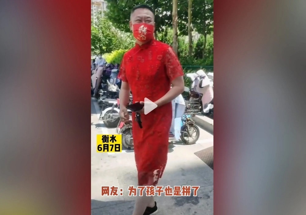 Đàn ông Trung Quốc đua nhau mặc sườn xám để cổ vũ sĩ tử thi Đại học - Ảnh 1.