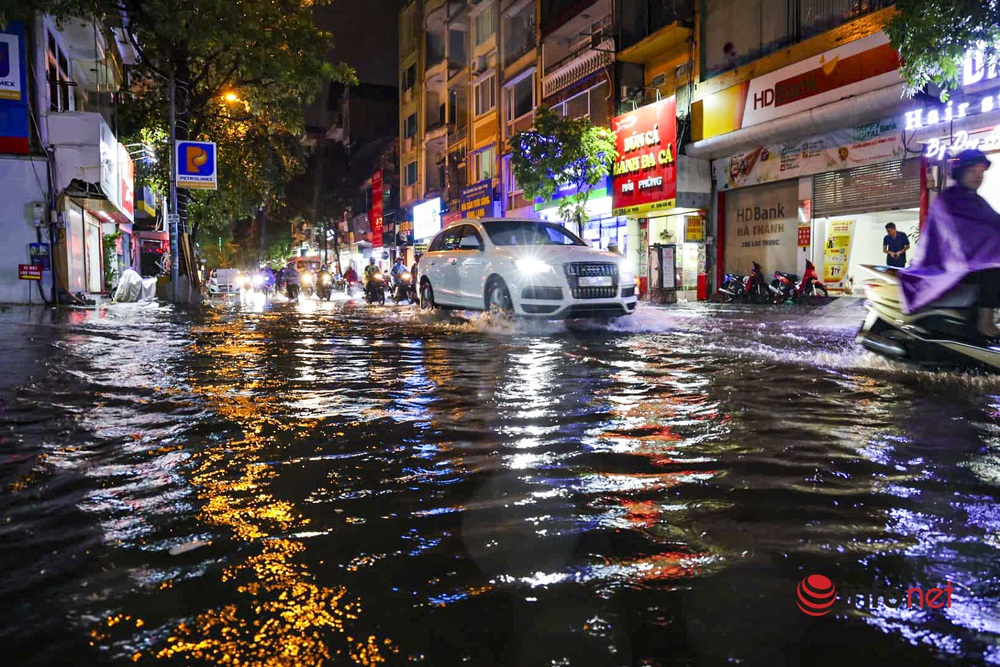 Hà Nội: Cơn mưa lớn kéo dài, nhiều tuyến phố ngập úng, người dân phải dùng xô tát nước ra khỏi nhà - Ảnh 1.