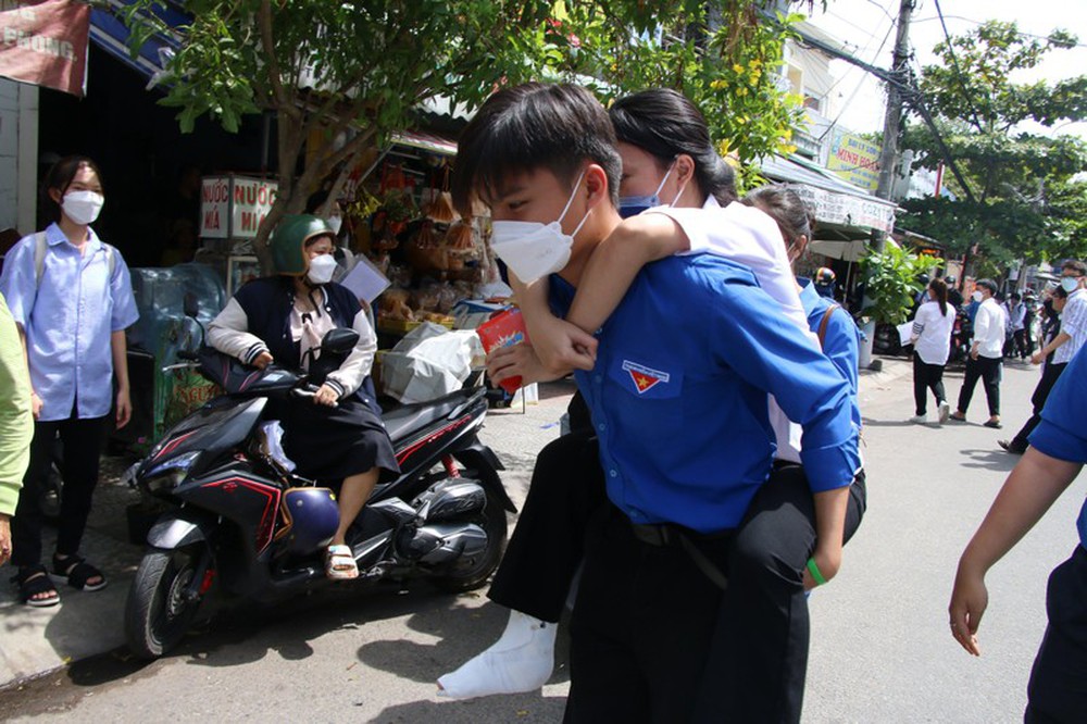 Nam sinh lớp 11 ở Đà Nẵng cõng thí sinh bị gãy chân vào phòng thi - Ảnh 1.