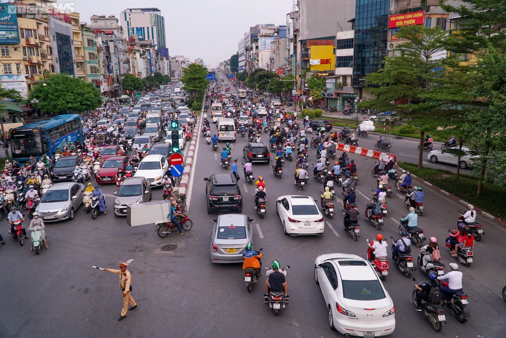 Lái xe máy vô tư đi ngược chiều trước mặt CSGT tại nút giao thông ‘nóng’ Hà Nội - Ảnh 2.