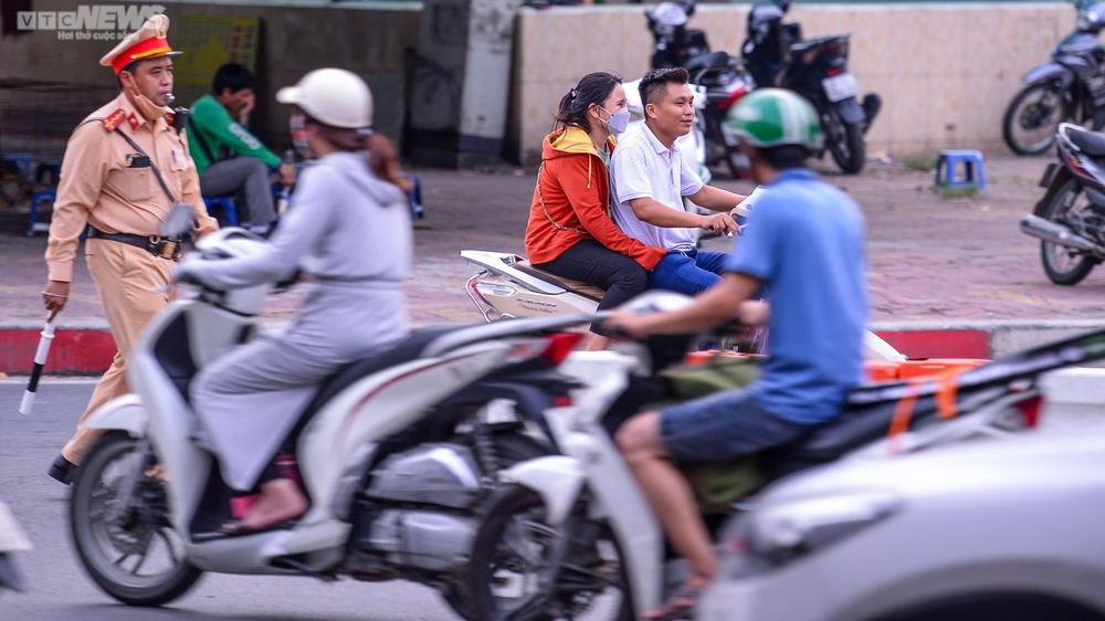 Lái xe máy vô tư đi ngược chiều trước mặt CSGT tại nút giao thông ‘nóng’ Hà Nội - Ảnh 4.