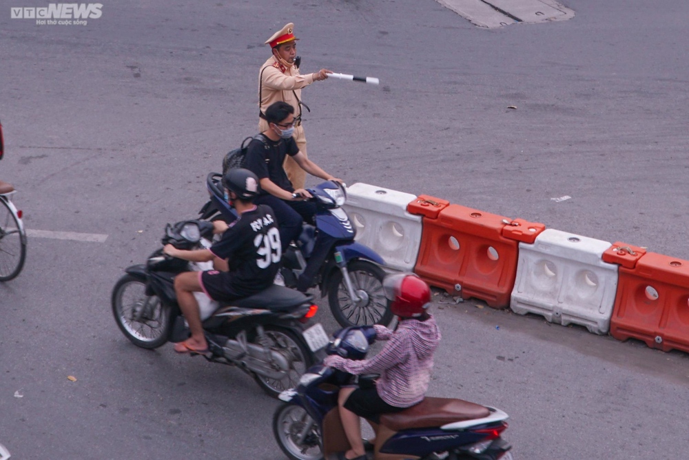 Lái xe máy vô tư đi ngược chiều trước mặt CSGT tại nút giao thông ‘nóng’ Hà Nội - Ảnh 5.