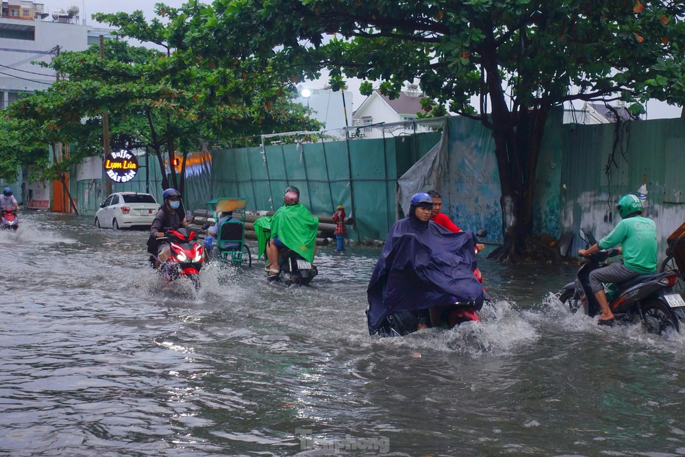 Người dân TPHCM bì bõm lội nước sau cơn mưa trắng trời chiều cuối tuần - Ảnh 1.