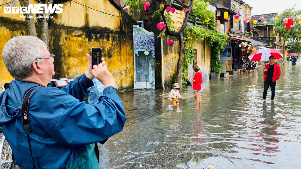 Du khách lội nước, bơi thuyền, ngồi xích lô tham quan phố cổ Hội An ngày lũ - Ảnh 4.