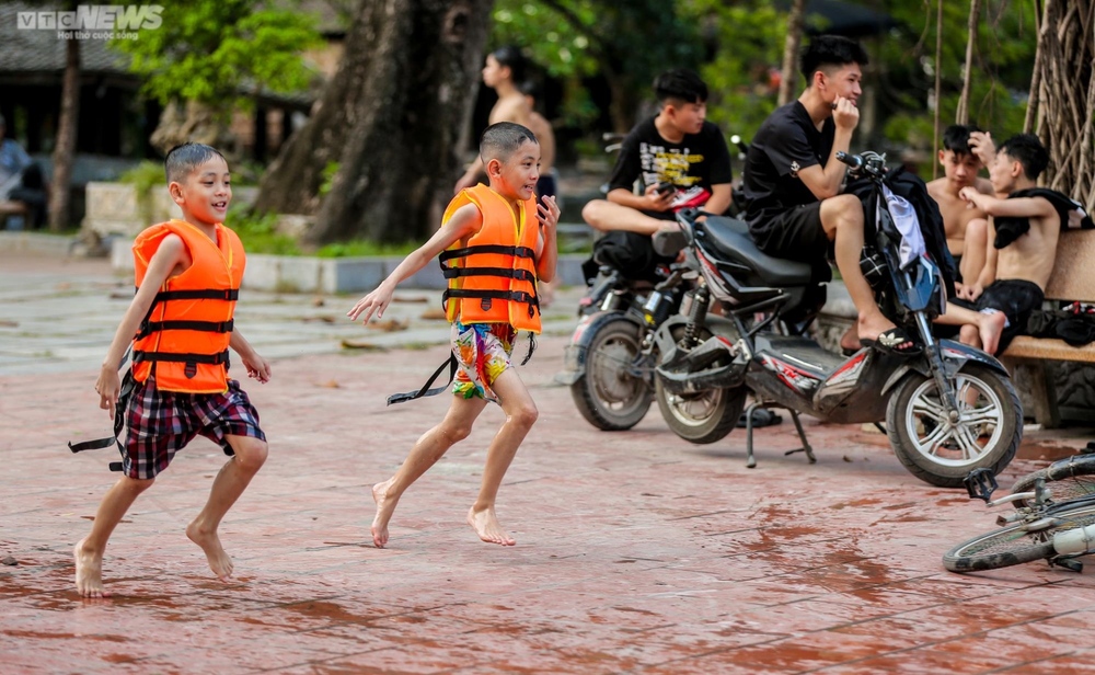 Trẻ em Hà Nội thích thú tắm giải nhiệt dưới hồ nghìn năm tuổi - Ảnh 6.