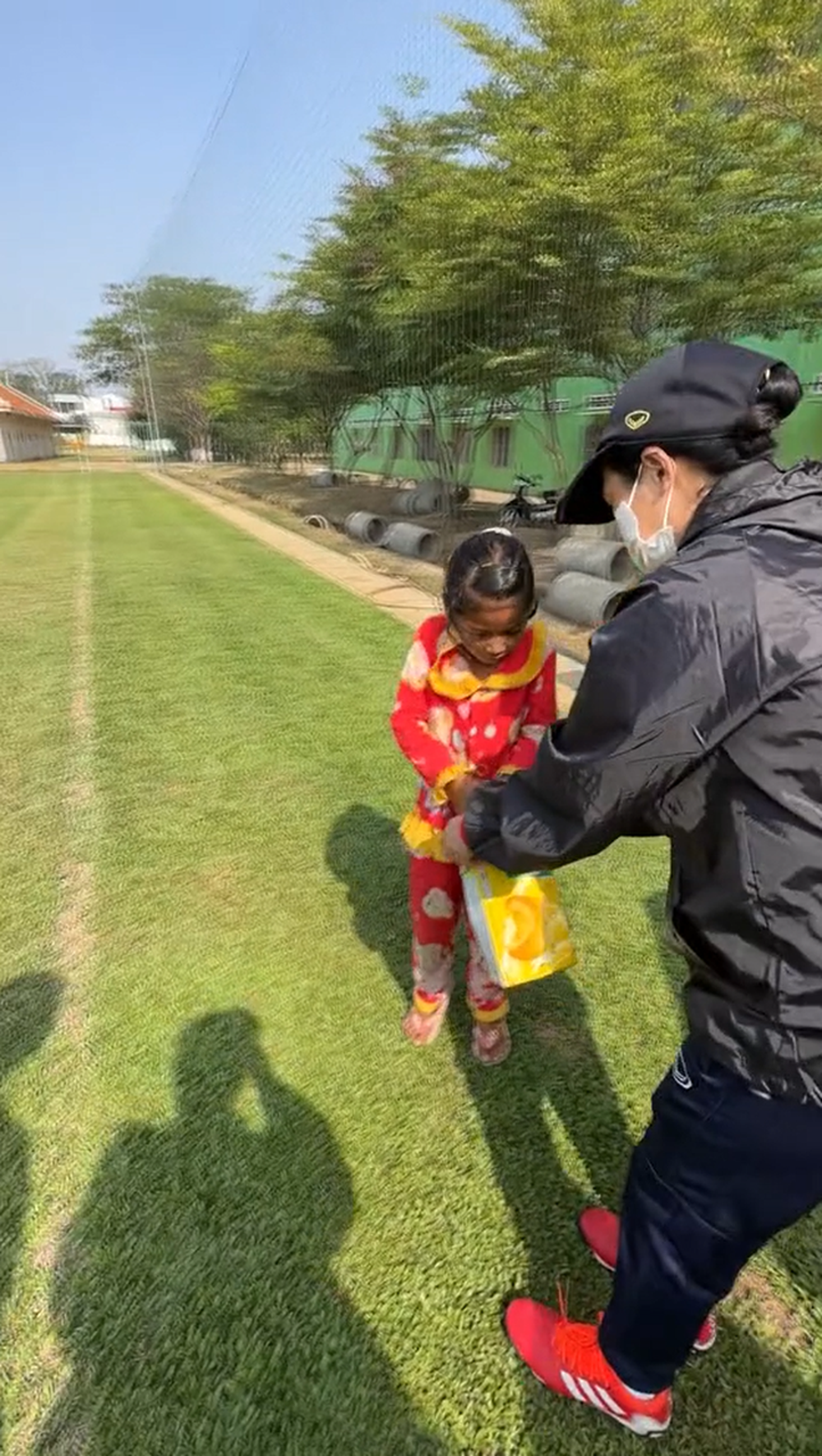 Góc đáng yêu: HLV Mai Đức Chung cho em bé Campuchia một vốc kẹo trong buổi tập của ĐT nữ Việt Nam ở SEA Games 32