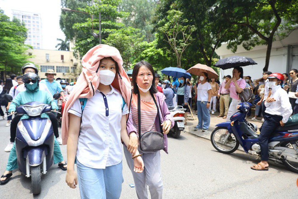 Nỗi lòng cha mẹ ngày con thi vào lớp 10: Phơi mình giữa nắng gần 40 độ, trải áo mưa xuống nền đất nóng đợi tin con