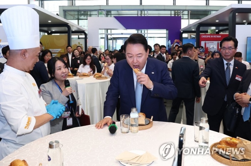 Tổng thống Hàn Quốc hào hứng ăn thử bánh mì kim chi tại Việt Nam - Ảnh 1.