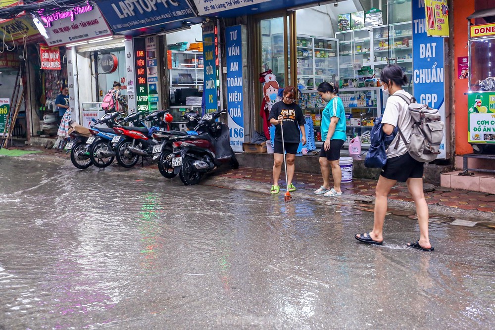 Người dân bì bõm về nhà trên những con phố ngập nước ở Hà Nội - Ảnh 14.
