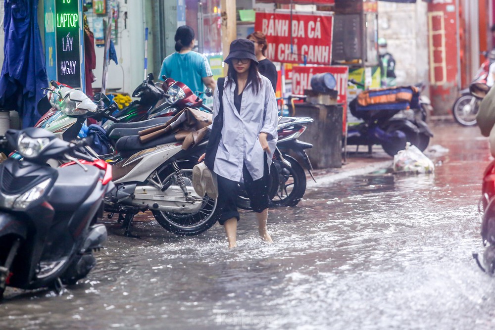 Người dân bì bõm về nhà trên những con phố ngập nước ở Hà Nội - Ảnh 13.