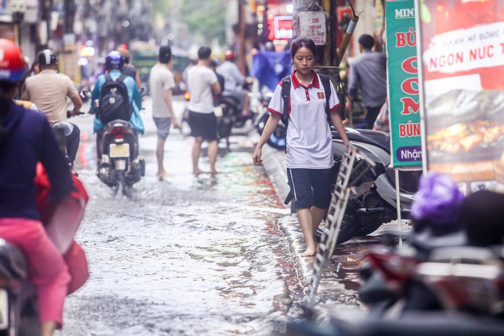 Người dân bì bõm về nhà trên những con phố ngập nước ở Hà Nội - Ảnh 12.