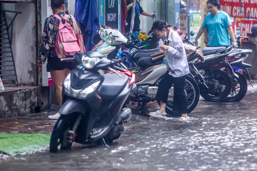 Người dân bì bõm về nhà trên những con phố ngập nước ở Hà Nội - Ảnh 11.