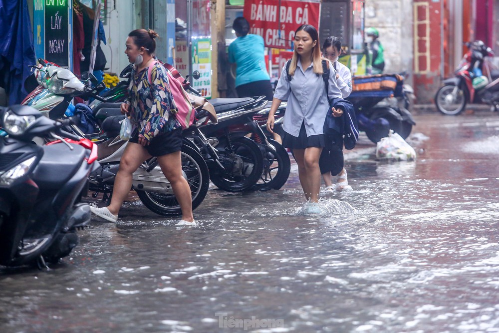 Người dân bì bõm về nhà trên những con phố ngập nước ở Hà Nội - Ảnh 10.