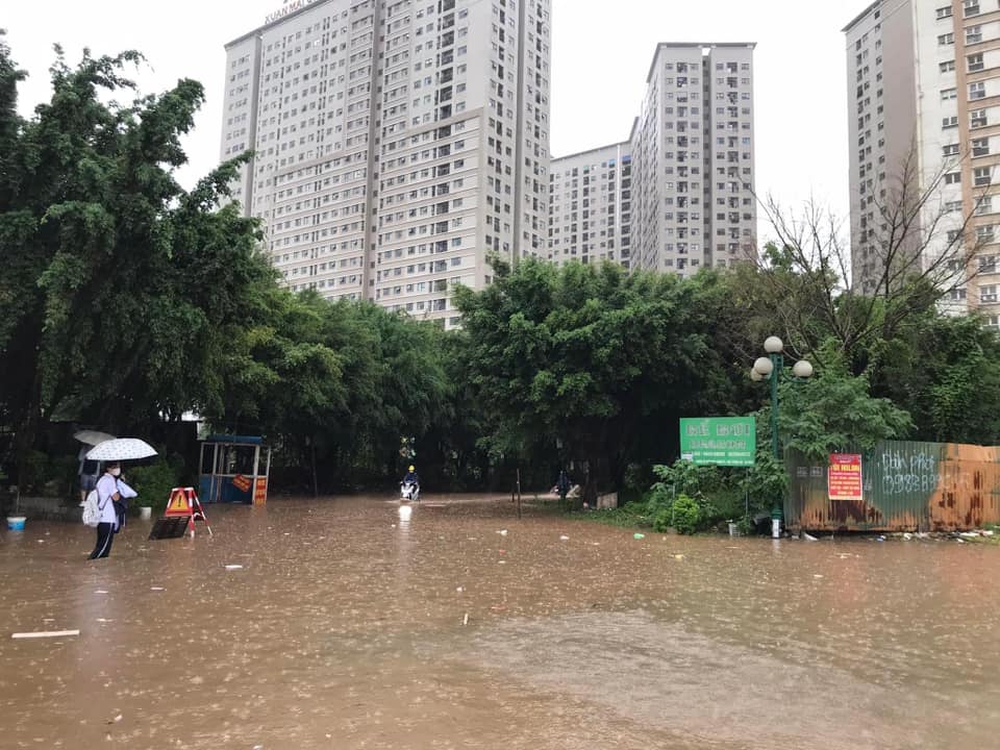 Đường Hà Nội có nơi ngập gần 1m trong sáng nay, người dân ngồi lên nóc xe chờ nước rút - Ảnh 1.