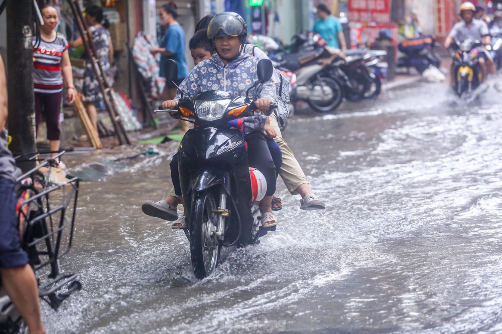 Người dân bì bõm về nhà trên những con phố ngập nước ở Hà Nội - Ảnh 9.