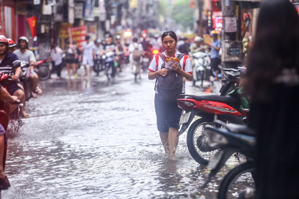 Người dân bì bõm về nhà trên những con phố ngập nước ở Hà Nội - Ảnh 8.