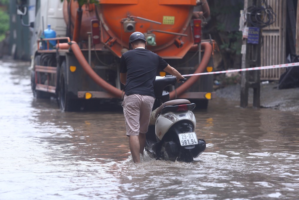 Một con phố ở Thủ đô vẫn chìm trong biển nước sau một ngày mưa lớn - Ảnh 10.