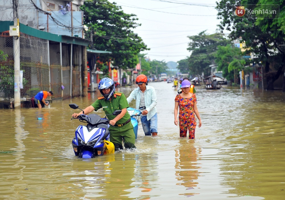 Chùm ảnh: Kiếm bộn tiền từ việc chèo đò qua điểm ngập nặng trong đợt lụt lịch sử tại Ninh Bình - Ảnh 1.