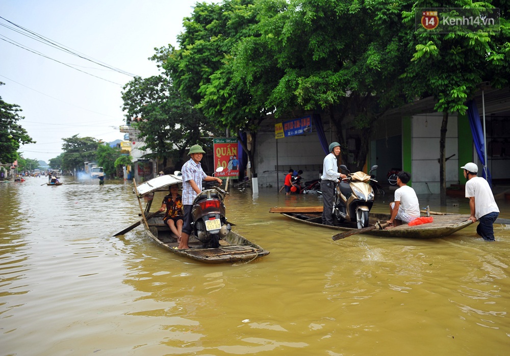 Chùm ảnh: Kiếm bộn tiền từ việc chèo đò qua điểm ngập nặng trong đợt lụt lịch sử tại Ninh Bình - Ảnh 4.