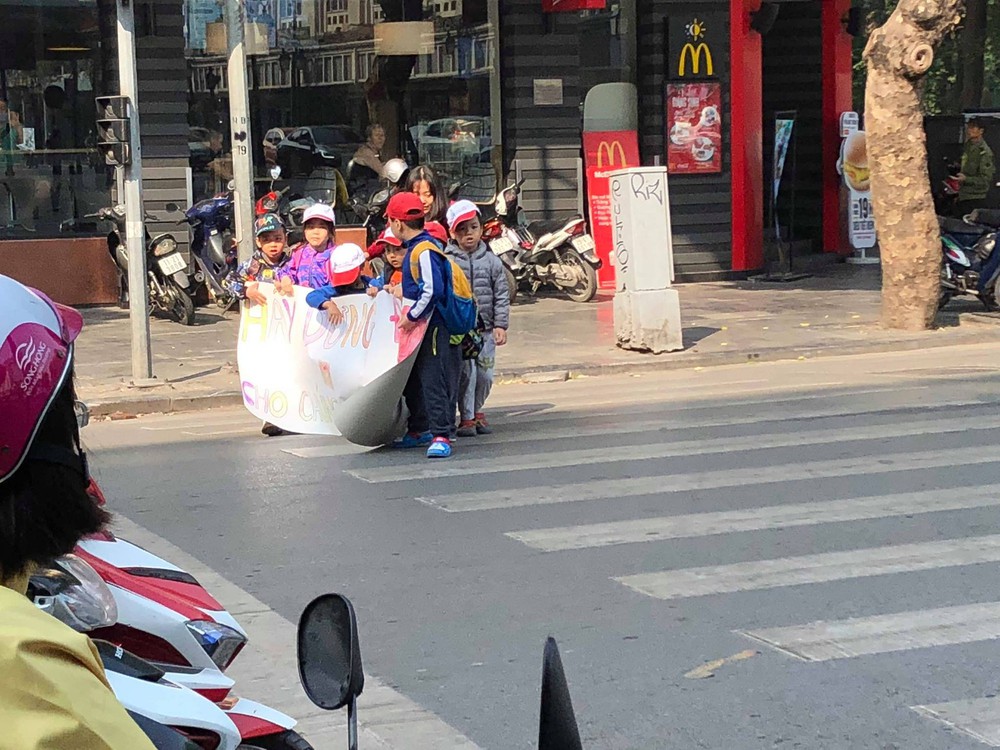 Các bé mẫu giáo cầm tờ giấy lon ton sang đường, dòng chữ bên trên khiến người lớn chột dạ - Ảnh 2.