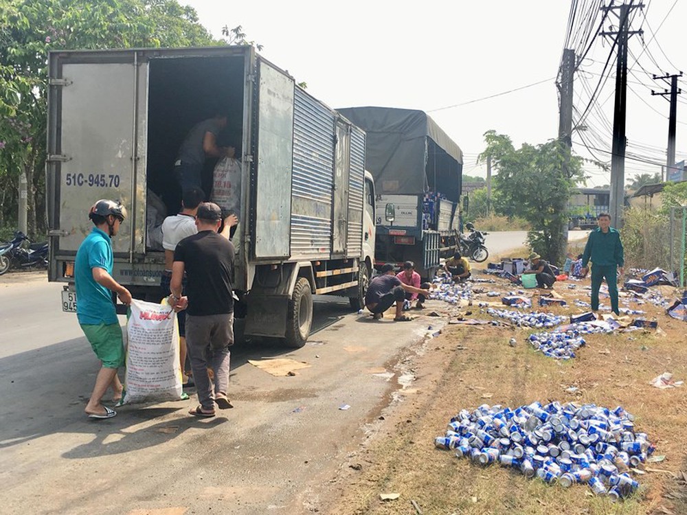 Người dân giúp tài xế thu gom bia rơi xuống đường
