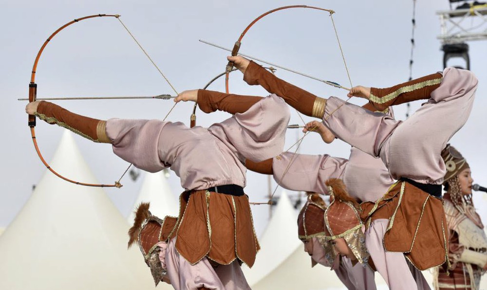 24h qua ảnh: Các nữ vũ công xinh đẹp trình diễn bắn cung tên bằng chân trên sa mạc - Ảnh 3.