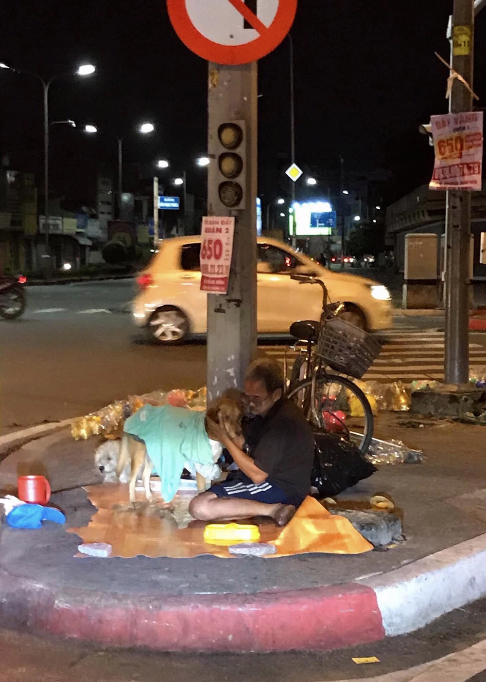 Hình ảnh cay mắt ở góc phố Sài Gòn: Cụ ông vô gia cư nhường áo, bón từng thìa thức ăn cho 2 con chó bị bỏ rơi - Ảnh 1.