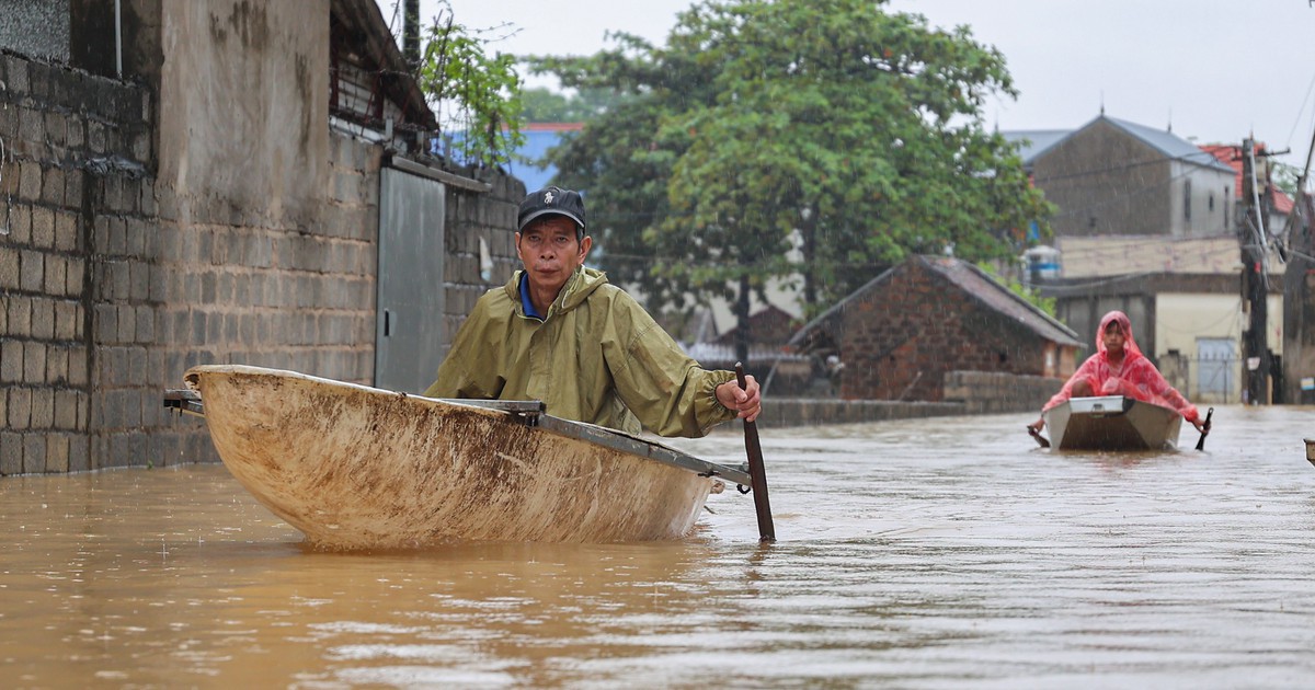 Ngập 3 ngày chưa rút, người dân ngoại thành Hà Nội chèo thuyền đi lại giữa làng