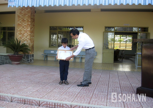 Lãnh đạo UBND huyện Tân Phú trao giấy khen và tiền thưởng cho em Nguyễn Ngọc Khang. Ảnh do trường tiểu học Trần Quốc Toản cung cấp.