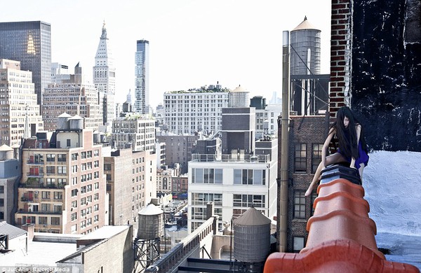 Unflappable: New York looms below as she crawls along the edge of a skyscraper. She started the photography project in 2008