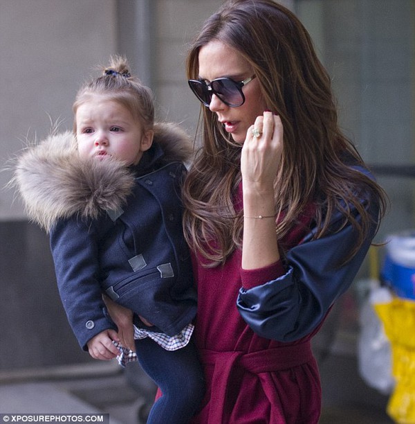 Baby's second New York Fashion Week! Harper looks adorable as she arrives in New York with a fur lined coat while mother Victoria opted for a chic maroon dress with leather effect sleeves 