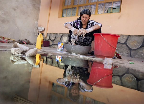 Fariha, 20 tuổi đang ngồi giặt quần áo ở trong khu vực trại giam ở Mazar-e-Sharif, Afghanistan