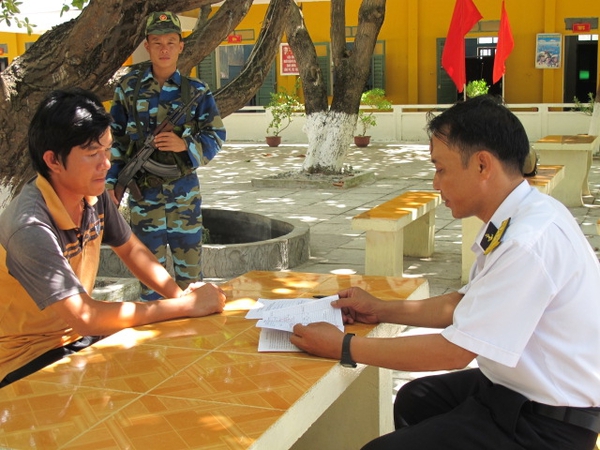 Chủ tàu cá Phan Quyết Công Minh (ở Nha Trang, Khánh Hòa) đang được trung tá Hà Hùng Long hướng dẫn làm thủ tục xin hỗ trợ dầu và thuốc men từ đảo