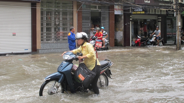 
	Nhiều người dân phải dắt xe máy bì bõm dưới dòng nước - Ảnh: Thân Hoàng