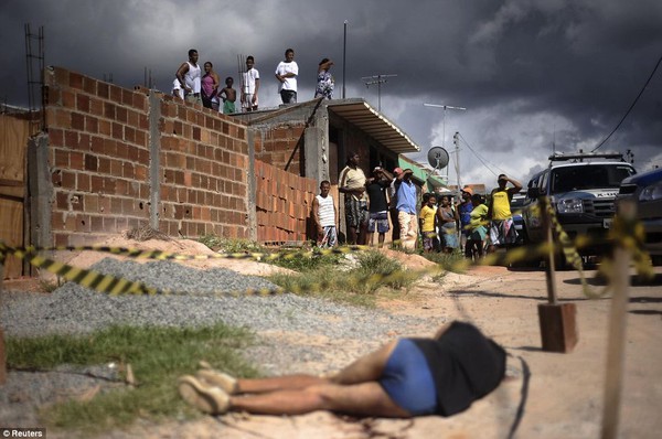 Người dân đứng xung quang xác một phụ nữ bị bắn vào đầu tại khu ổ chuột Sao Cristovao.