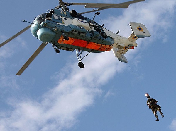 Một lính biệt kích được thả từ trực thăng xuống đất bằng dây.