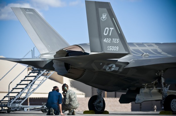 Các nhân viên kỹ thuật thảo luận với nhau trong khi kiểm tra “tia chớp” F-35A Lightning II.