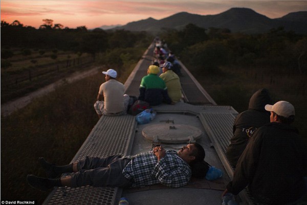 Những người di cư ngồi trên nóc của một đoàn tàu chờ hàng đến phía bắc để cố gắng vượt biên sang Mỹ. Di chuyển bằng tàu hỏa rất nguy hiểm vì có thể bị các băng nhóm tội pháp cướp bóc hay bắt cóc.