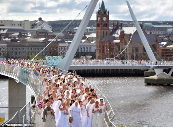 
	Hàng trăm phụ nữ mặc trang phục váy cô dâu cùng tập trung trên cây cầu Peace Bridge.