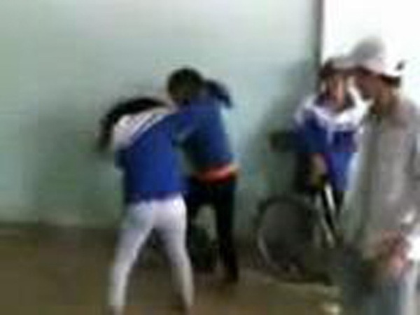 Hai nữ sinh vừa đánh nhau vừa văng ra những lời tục tĩu trong khi những học sinh khác đứng ngoài cổ vũ là học sinh Trường THPT Đinh Chương Dương (ảnh cắt từ video).