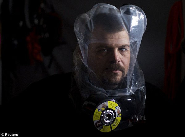 Escape plan: Phil Burns demonstrates the air purifying SCape Mask at his home in American Fork, Utah