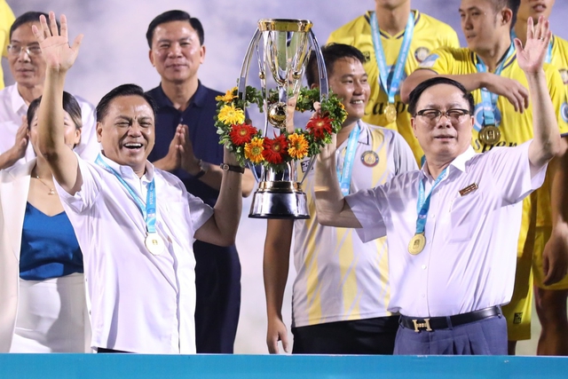 Hai ông bầu V.League nổi tiếng nắm chặt tay nhau, cùng nâng cúp sau trận thắng đội bầu Hiển- Ảnh 1.