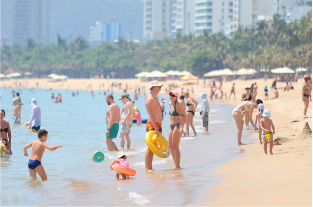 Bãi biển Việt Nam được khách Tây yêu mến, dù trưa nắng gắt vẫn kín người - Ảnh 1.